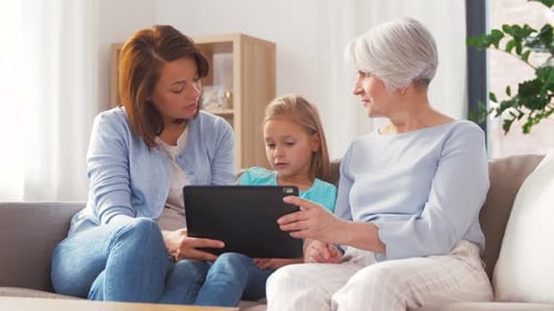 Family using tablet together on couch indoors