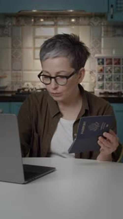 Adult at Laptop Looking at Passport