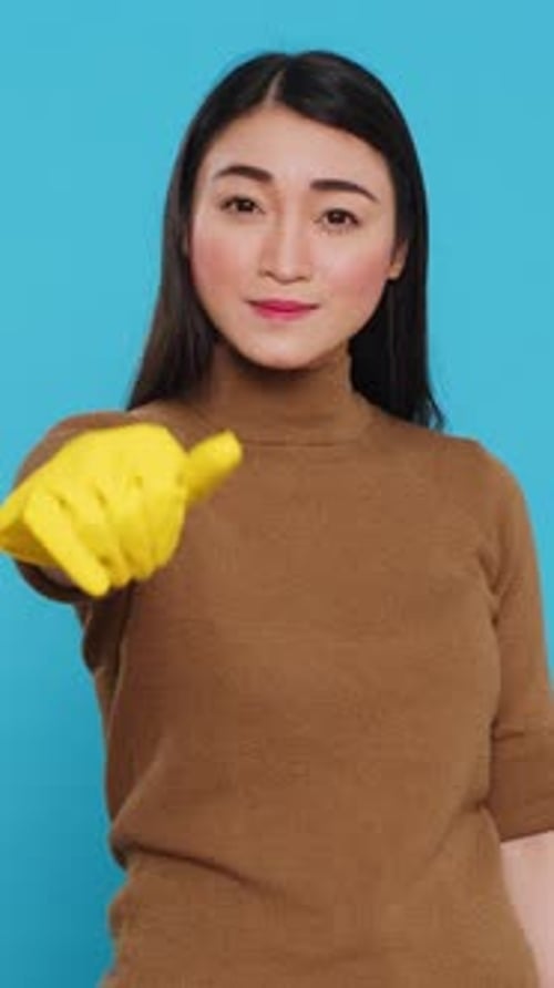 Vertical Video Joyful Maid Posing in Studio Doing Approve Gesture in Front of Camera After Finishing