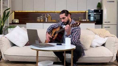 Man Plays Guitar in Living Room at Home
