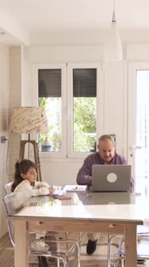 Child Drawing as Adult Uses Laptop Indoors