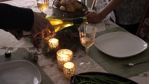 Wine poured at festive dinner table with candles