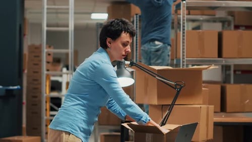 Woman Packs Box in Warehouse
