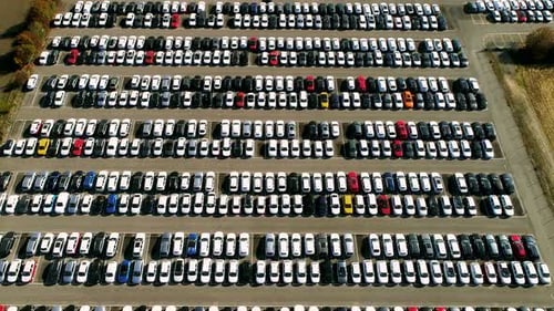 Aerial footage of finished cars ready to be shipped on huge distribution center