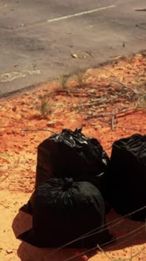 Closeup of Full Trash Bags on the Sand
