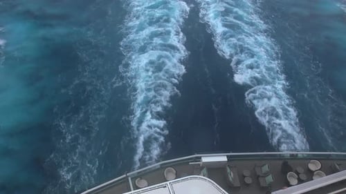 A tugboat is attached to the stern of a ship and floats behind it.
