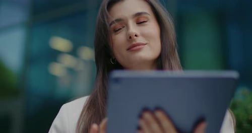 Young Woman Uses Tablet Device Outdoors