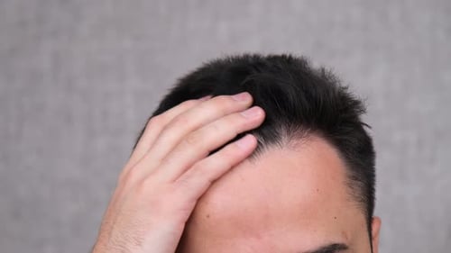 Man Touching and Styling Short Dark Hair