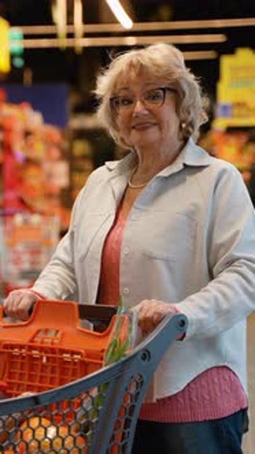 Smiling Senior Woman Shopping in Supermarket Aisle