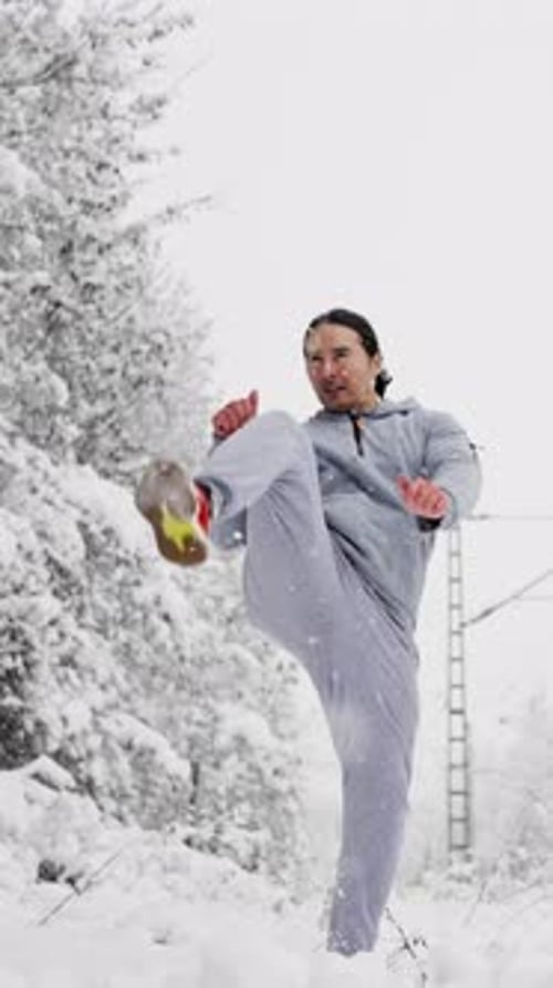 Man Kicks in the Air in the Snow
