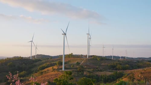 Aerial drone shot flying outdoors above the wind turbine field.