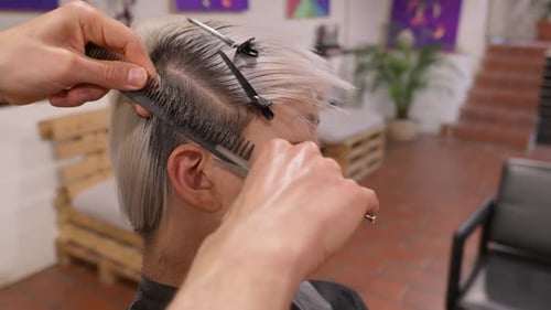Hairstylist Perfecting Edgy Haircut with Precision and Care