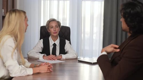 Rear View of Successful Businessman in Suit Giving Money to Grateful Professional Middleaged Female