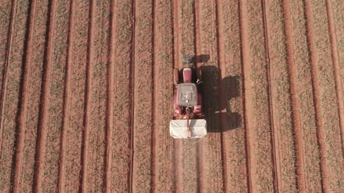 Pesticide Sprayer Tractor working on a large field, Aerial follow footage