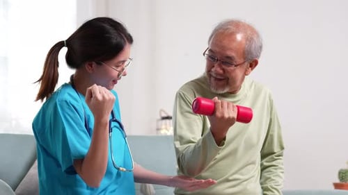 Woman Helps Senior Man Lift Dumbbell