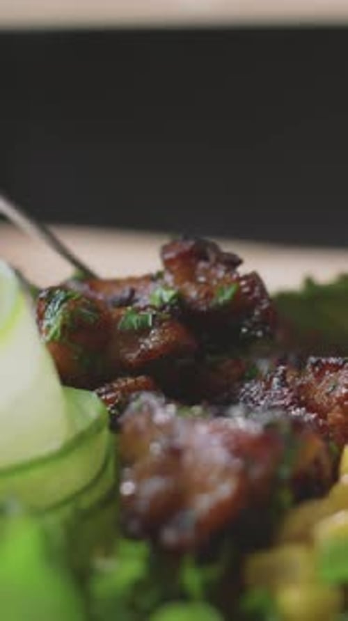 Close-up of Unrecognizable Hands Arranging Cooked Meat Atop Vegetable Salad