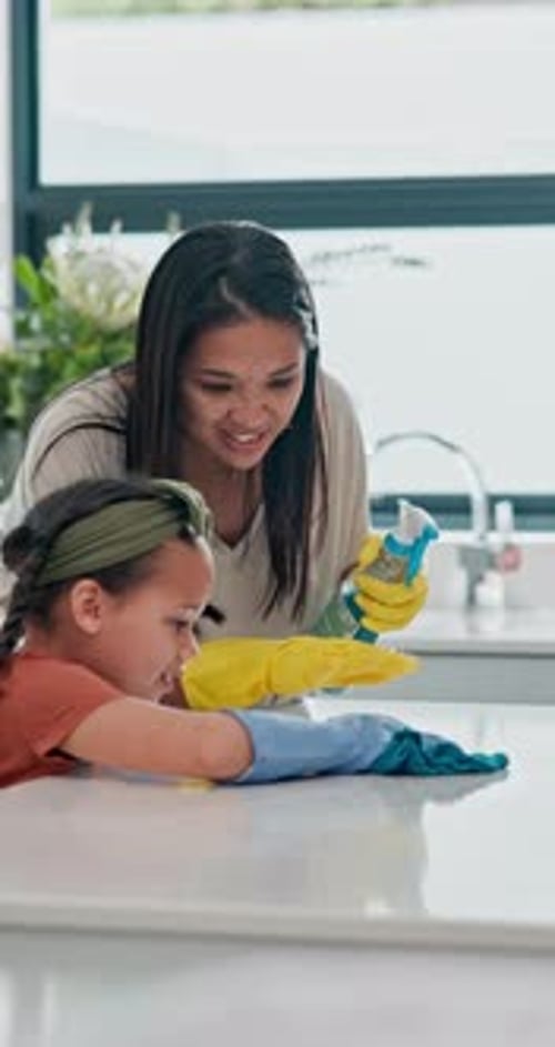 Home, mother and daughter with spray, wipe surface and teaching with kitchen counter