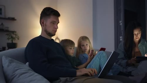 Family Together on Couch Using Electronic Devices