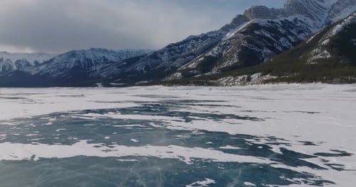 people walking on frozen lake abraham with canadian rocky mountains during winter