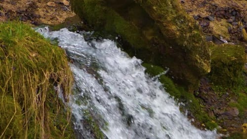 Close-up waterfall, water falling and bubbling slow motion