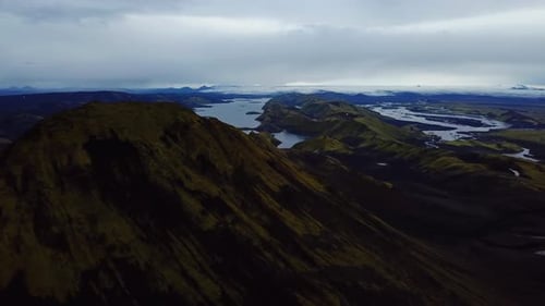 Aerial landscape view of Icelandic highlands, dark mountain peaks, rivers and lakes, on a moody day