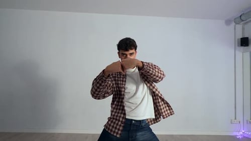 Energetic male dancer performing dynamic choreography in studio