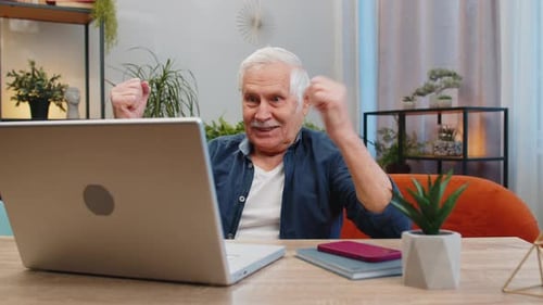 Overjoyed Senior Man Working on Laptop Celebrate Success Win Money in Lottery Get Online Good News