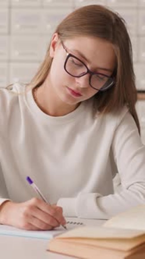 Young Woman Writes Notes in University Library