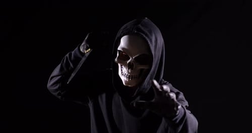 Masked Figure Waving Knife in the Dark