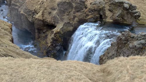 Waterfall Splashing Through Rugged Cliffside Canyon
