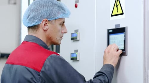 Factory Worker Working with Touch Screen Display of Industrial Computer Equipment. Technical