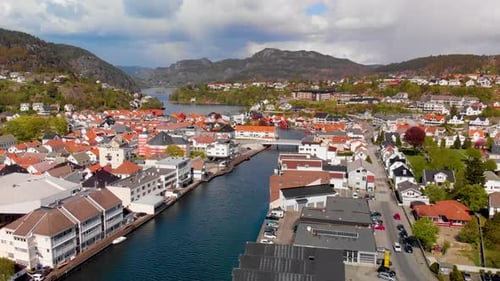 Drone shot of the Flekkefjord harbour, city and mountains. Slow descent in 4K.