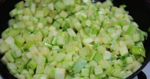 Diced Zucchini Being Stirred with Spatula in a Pan