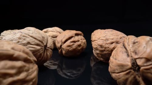 Close Up Walnuts on Black Reflective Surface