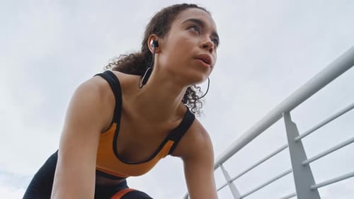 Mulher, marque e comece a correr na cidade com fones de ouvido, exercícios intensos ou treinamento de resistência