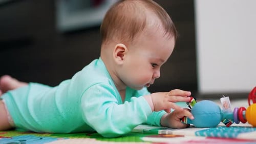 Baby Lying Down Playing with a Toy