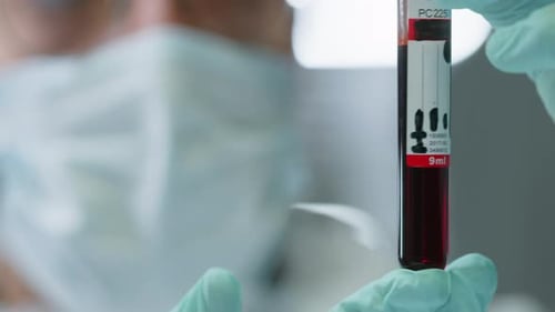 Close Up of Scientist Holding Test Tube with Red Liquid