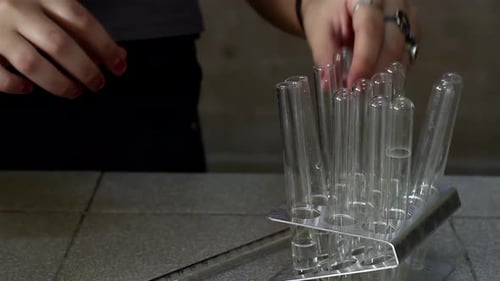 Estudiante de secundaria organizando tubos de ensayo en el aula de química.