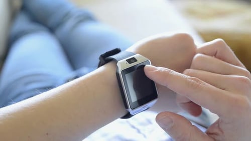 Young Man Using a Smartwatch Indoors at Home