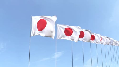 Multiple Japanese Flags Waving Against a Clear Blue Sky