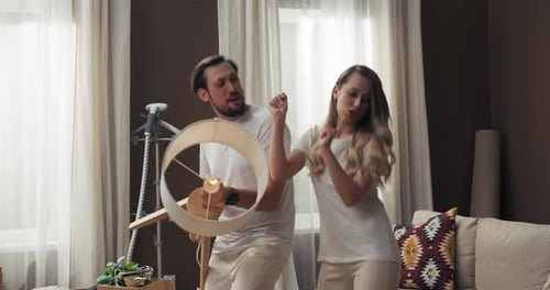 Happy Delighted Young Wife Woman with Handsome Husband in New Modern Apartments Moving in Dancing