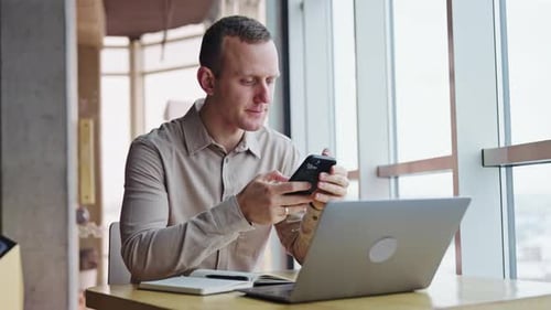 Man Working on Laptop in Modern Office