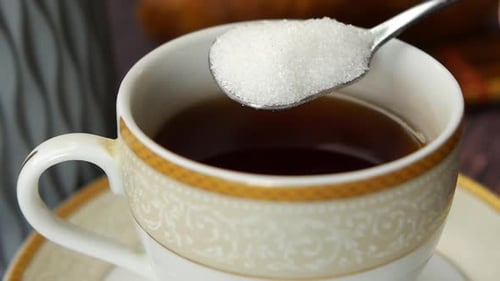 Slow Motion of Pouring White Sugar in a Coffee Cup Top View