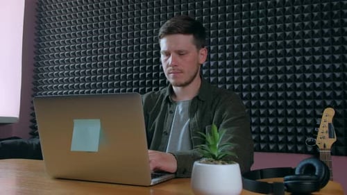 Sound Designer Working on Notebook in Music Studio