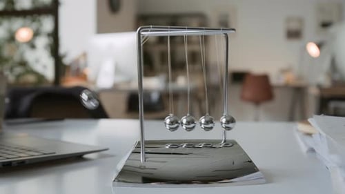 Close up of Moving Newtons Cradle in Office