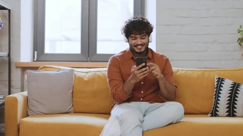 Man Enjoying Mobile Phone on Cozy Sofa