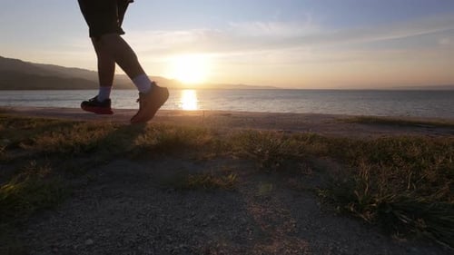 Person Jogging by the Lake at Sunset