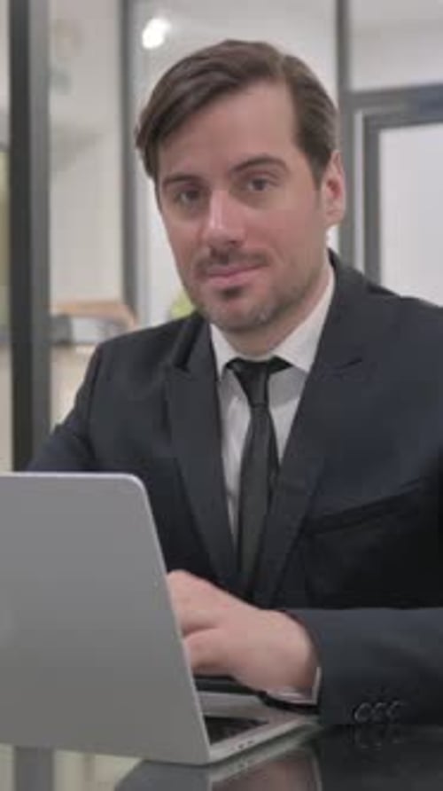 Positive Businessman Working on Laptop Gives Thumbs Up