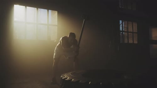 Muscular Man Works Out with Sledgehammer in Gym