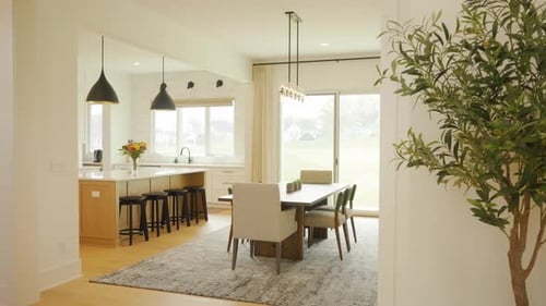 Clean white stylish modern dining seating area with wooden flooring and elegant lighting